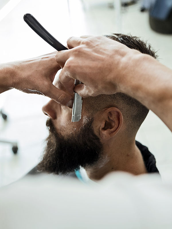Barber shaves the beard of the client
